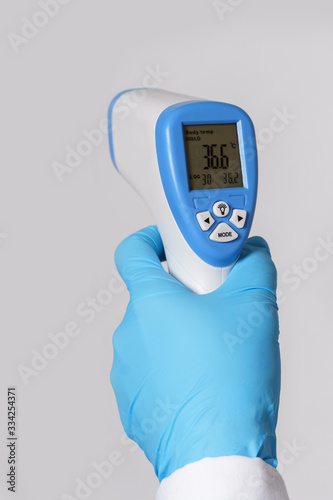 Doctor is holding a digital infrared thermometer photo