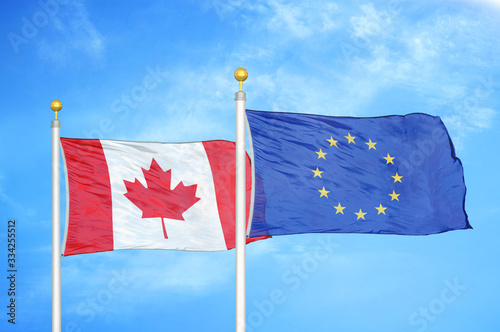 Tableau sur toile Canada and European Union two flags on flagpoles and blue cloudy sky