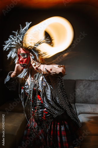 A girl in chaotic clothing and a red stocking mask on her face is in a panic