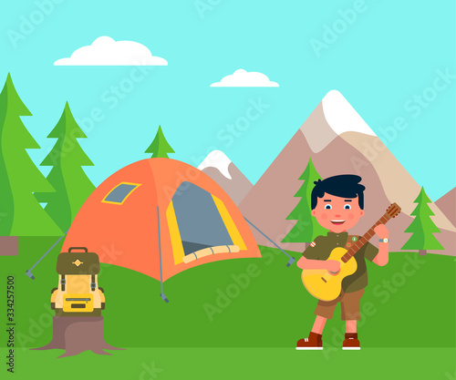 Happy boy scout playing guitar in mount campsite