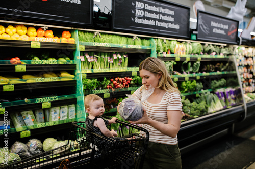 mother and daughter grocery shopping for organic vegetables