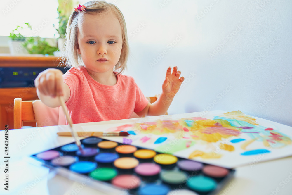 Girl drawing rainbow with colorful aquarelle paints Girl drawing rainbow with colorful aquarelle paints