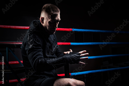 Mixed martial artist wraps bandages around his fist. Concept of mma, ufc, thai boxing, classic boxing. photo