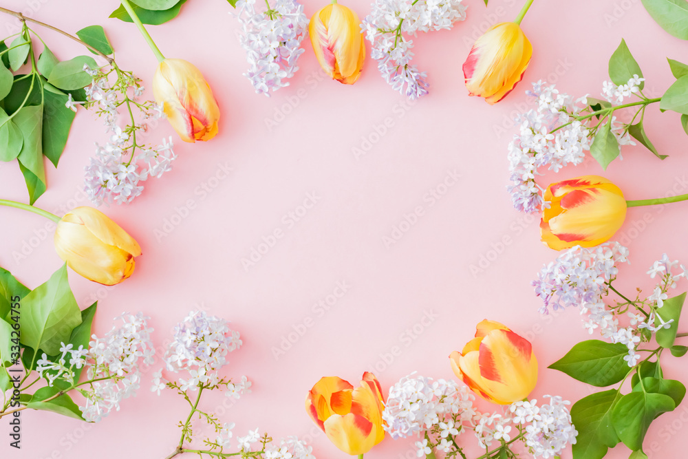 Flat lay composition with branches of lilac and yellow tulips on a pink background Flat lay composition with branches of lilac and yellow tulips on a pink background