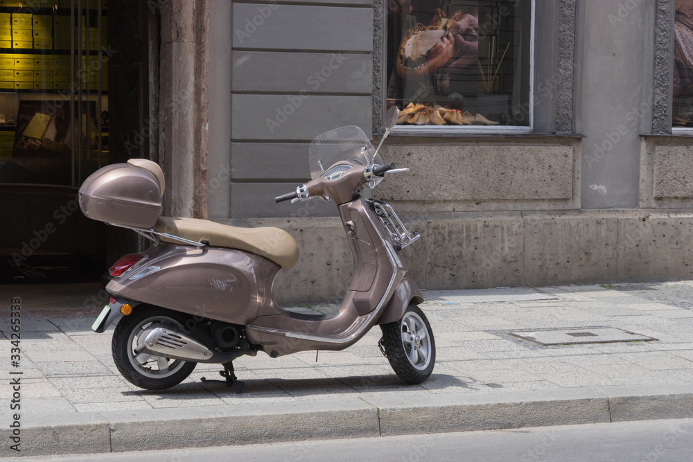 Italienisches Flair: alter Vespa-Roller vor Fassade mit Laden für Lederschuhe	