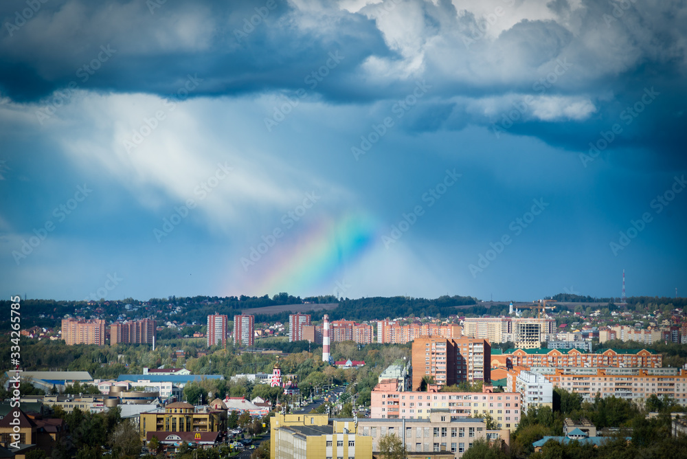 panorama of the city with rainbow and sun