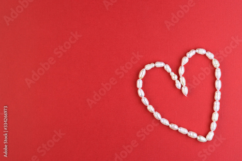 white pearl heart on a red background  top view