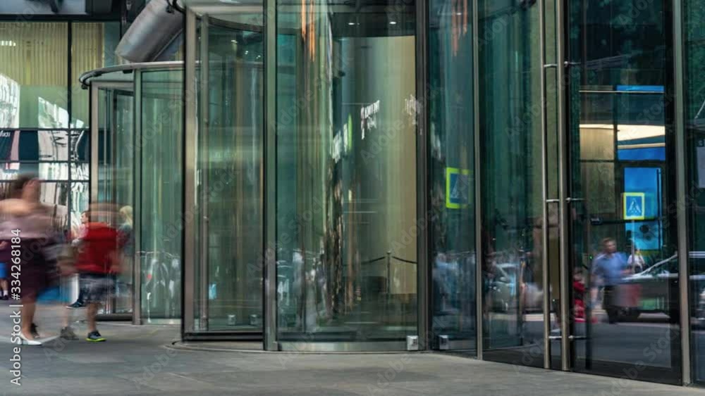  the flow of people passing through the revolving door of the modern office building at the end of the working day,time lapse