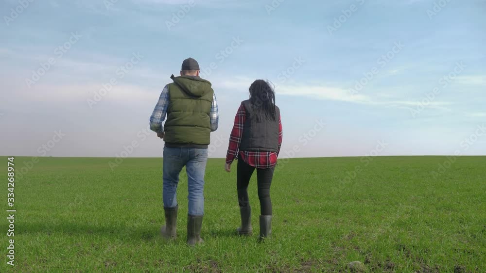happy family of farmers teamwork red neck works go on the green field. man and girl farmer are studying eco farming farming harvesting concept. woman and worker go walking on agricultural land private happy family of farmers teamwork red neck works go on the green field. man and girl farmer are studying eco farming farming harvesting concept. woman and worker go walking on agricultural land private