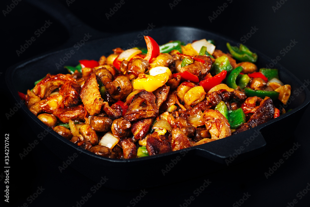 Fried meat and vegetables in cast iron pan