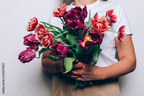 Fototapeta Naklejka Na Ścianę i Meble -  Beautiful Bunch of Peony Style Tulips in the hands of young woman, spring holiday concept, copy space, present for mothers day from kids
