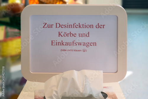View of a sign in a supermarket. One asks to disinfect the handle of the shopping trolley and not to steal the disinfectant.