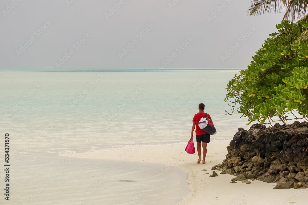 a man from behind walking on a beautiful beach