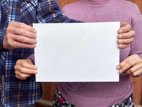 the hands of an old man and old woman hold a white sheet without a text. coronavirus, covid-19.