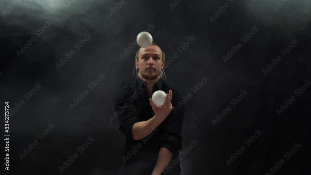 Man wearing a black juggling with white balls. Management, control and success Man wearing a black juggling with white balls. Management, control and success