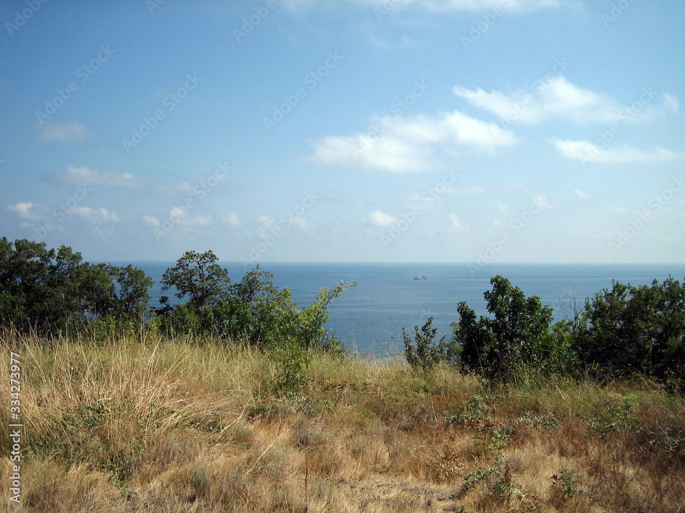 Sea view from the coastal mountains. The coastal hills are surrounded by dense vegetation. Sea view from the coastal mountains. The coastal hills are surrounded by dense vegetation.