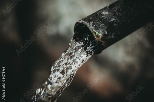 alter Wasserhahn und fließendes Wasser