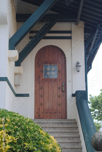 Porta de entrada em madeira com um postigo num alpendre de madeira de uma casa photo