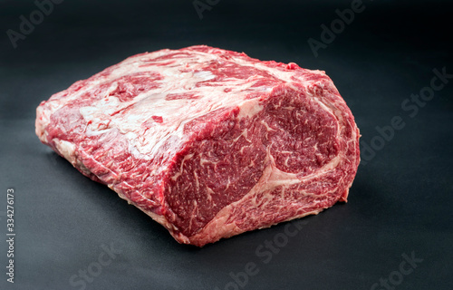 Raw dry aged wagyu entrecote beef steak roast as closeup on a black background with copy space photo