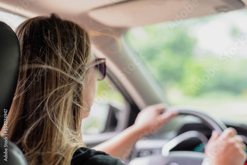Foto Over the shoulder view of attractive young woman driving on a summer day