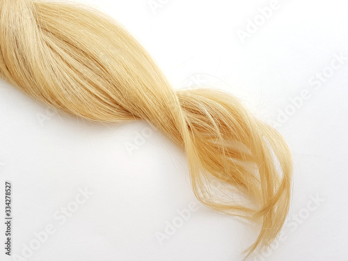 Curls of natural blonde hair on a white background.