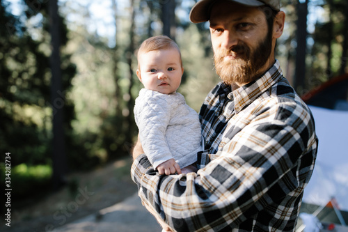 father and baby daughter camping in the woods