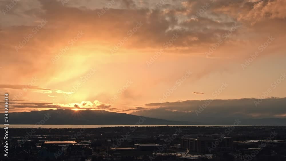 Sunset time lapse as light rain falls from the sky over Provo as the clouds light up in vibrant colors.