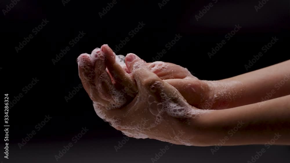 Close up of female lathering hands with soap before washing Black backgorund. Close up of female lathering hands with soap before washing Black backgorund.