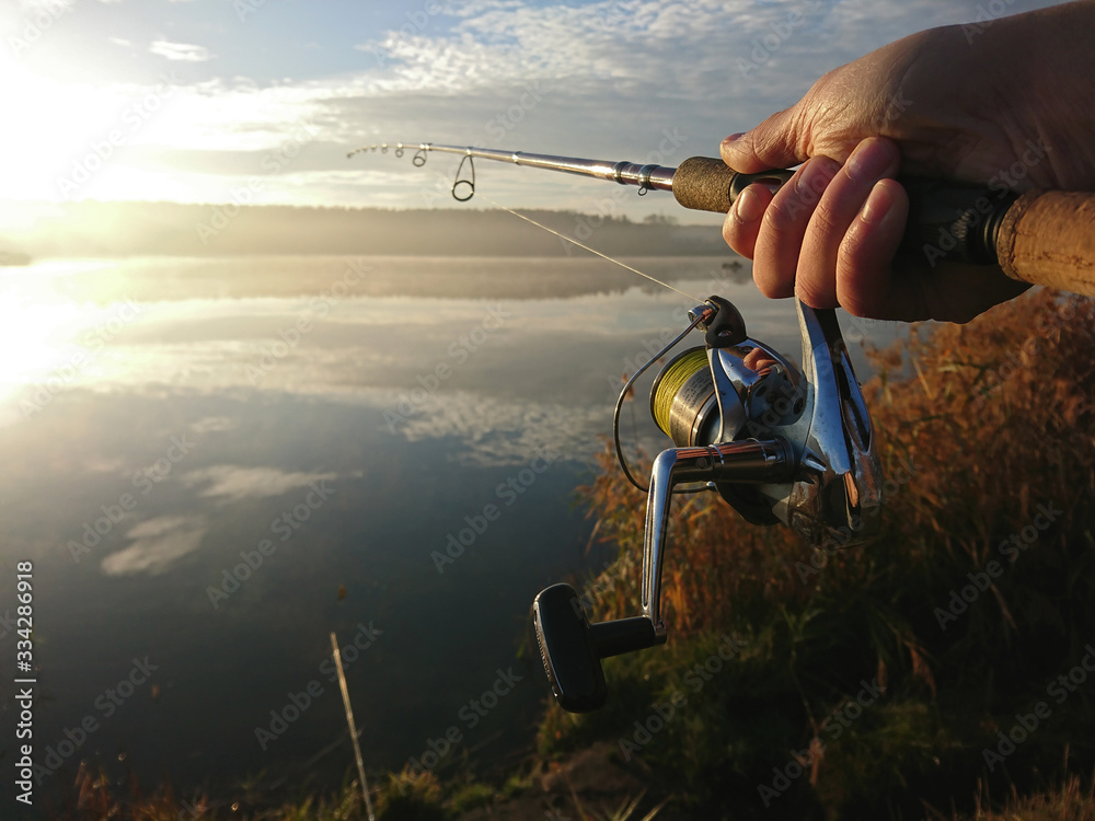 Amateur angler is fishing on autumn in the lake - obrazy, fototapety, plakaty 
