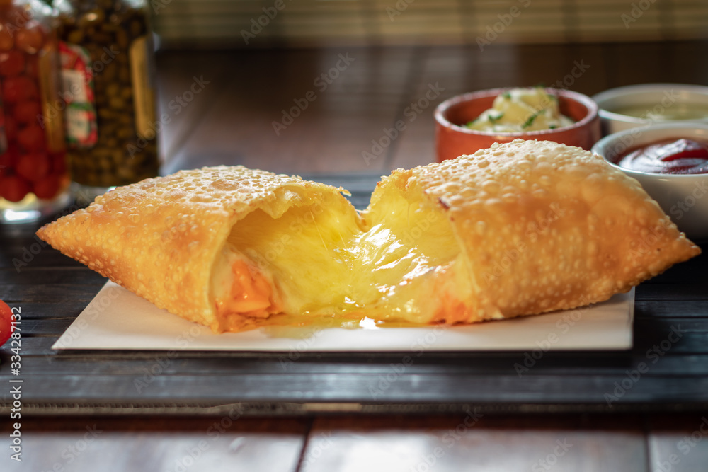 Pastel frito da culinária brasileira recheado com quatro queijos foto