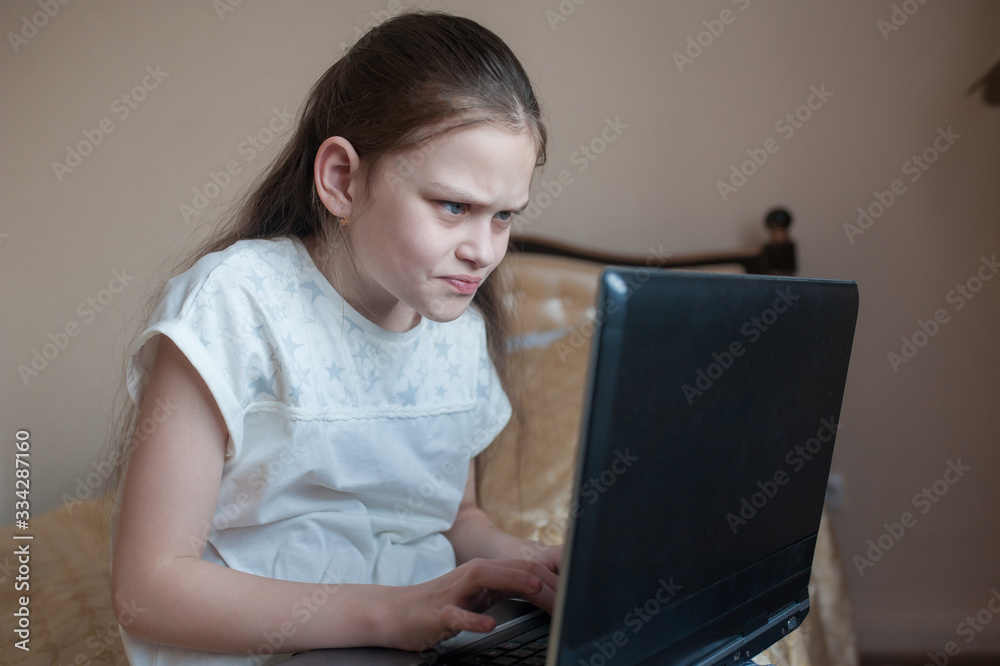 School girl studying online at home on the bed on the laptop. Stay at home. Coronovirus School girl studying online at home on the bed on the laptop. Stay at home. Coronovirus