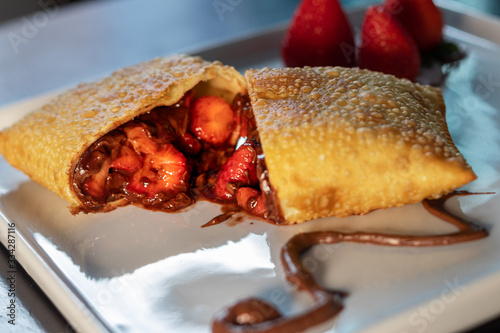 Pastel frito da caulinaria brasileira recheado com morango e chocolate doce