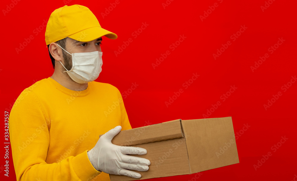 Delivery man holding cardboard boxes in medical rubber gloves and mask. copy space. Fast and free Delivery transport . Online shopping and Express delivery . Quarantine