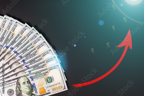 Closeup of one hundred dollars banknote on black background. Business finance and money concept  red arrow growing graph