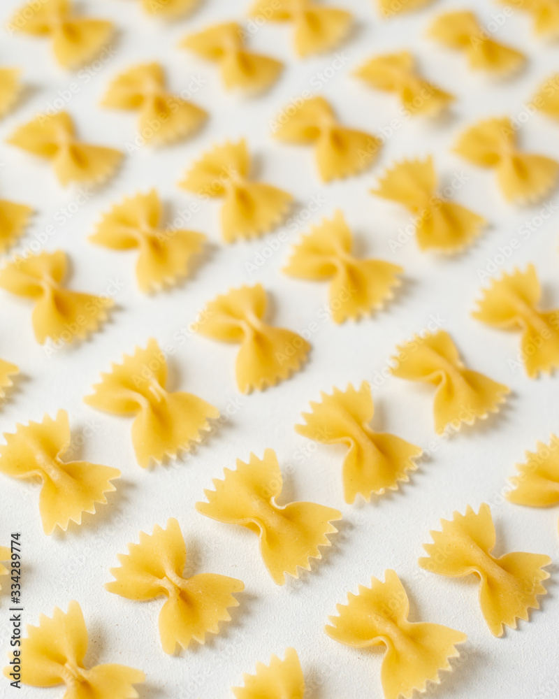 Obraz premium Pasta, durum wheat pasta in the form of bows, food pattern, top view, copy space flat lay