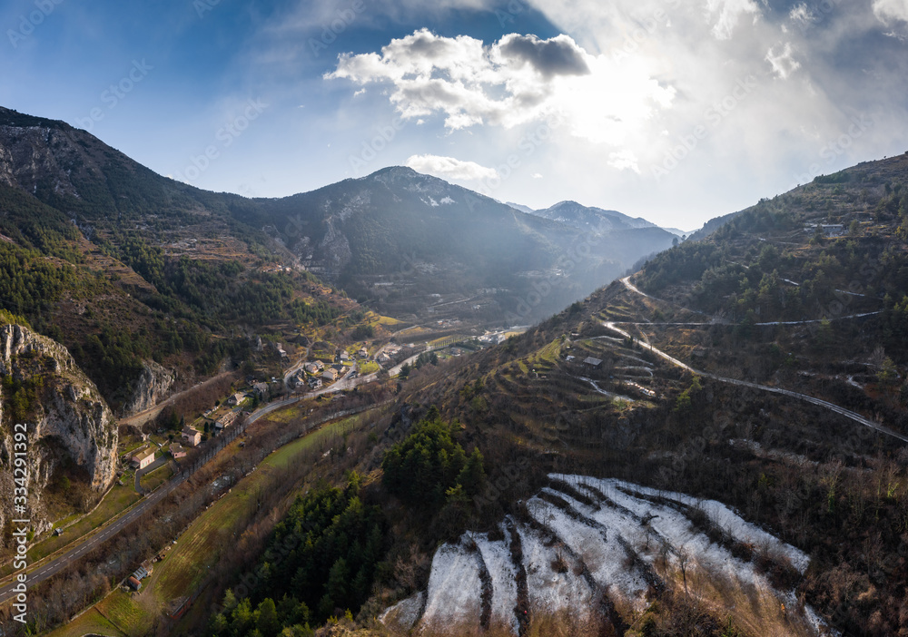 Aerial panoramic drone view of a scenic highway by the beautiful Landscape covered in clouds and fog, bridge and viaduct, The mountain river along the road, Snow-covered mountains on a background