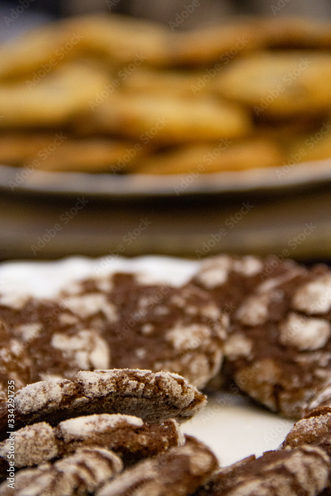 Biscoitos de chocolate branco e preto focado na frente e mais biscoitos desfocados ao fundo.
