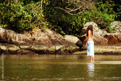 Woman contemplating a nature at the mouth of the river at Puruba beach - Ubatuba (SP) Brazil