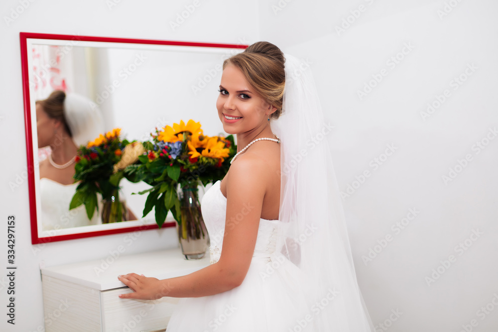 beautiful bride stands by the mirror, admiring herself beautiful bride stands by the mirror, admiring herself