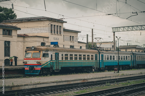 Ukrainian passenger train on the station of Zhmerynka during a small rain shower. Train waiting at the platform. Zhmerynka is an important rail junction in Ukraine
