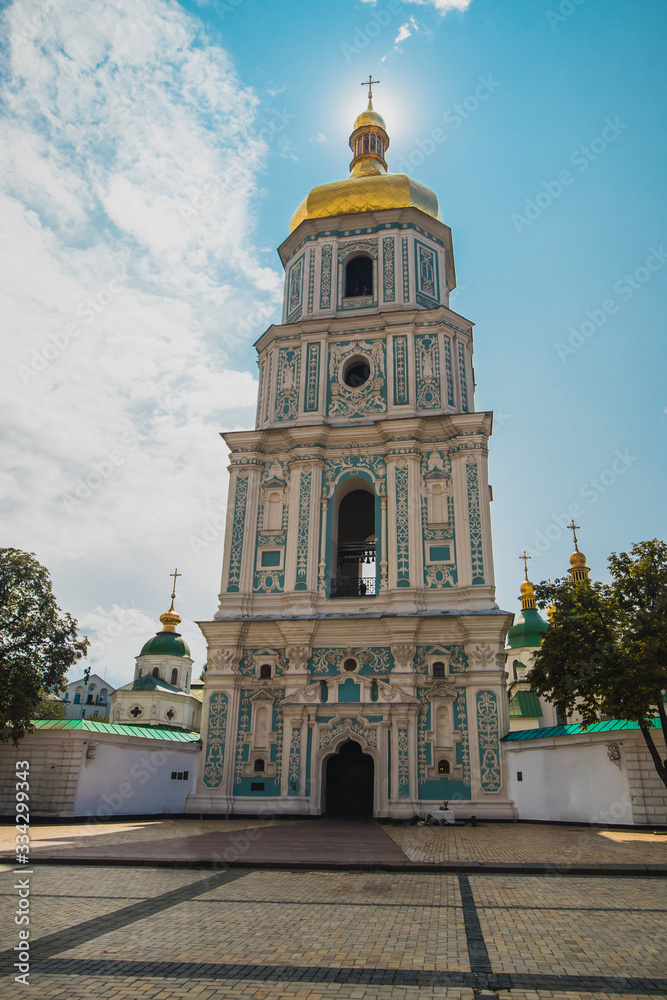 Bell tower of Sant Sophia cathedral in Kiev, Ukraine, viewed from below a sunny day in summer with sun directly behind the spire