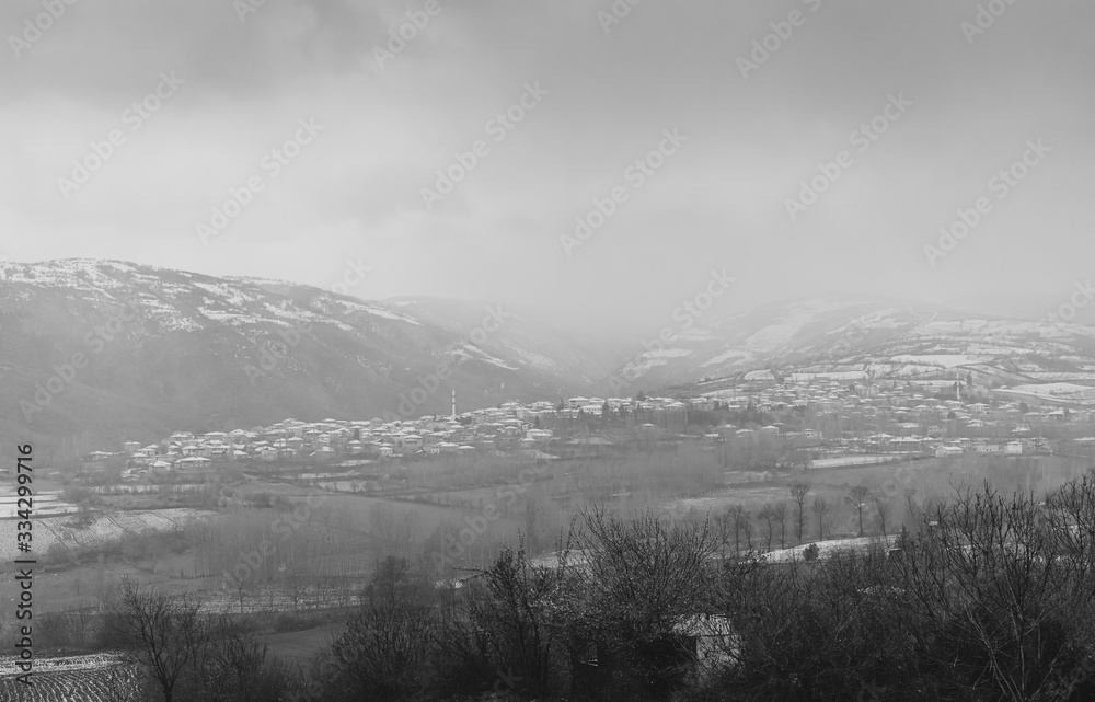 Foggy village landscape between snowy mountains. March 18, 2020 Turkey