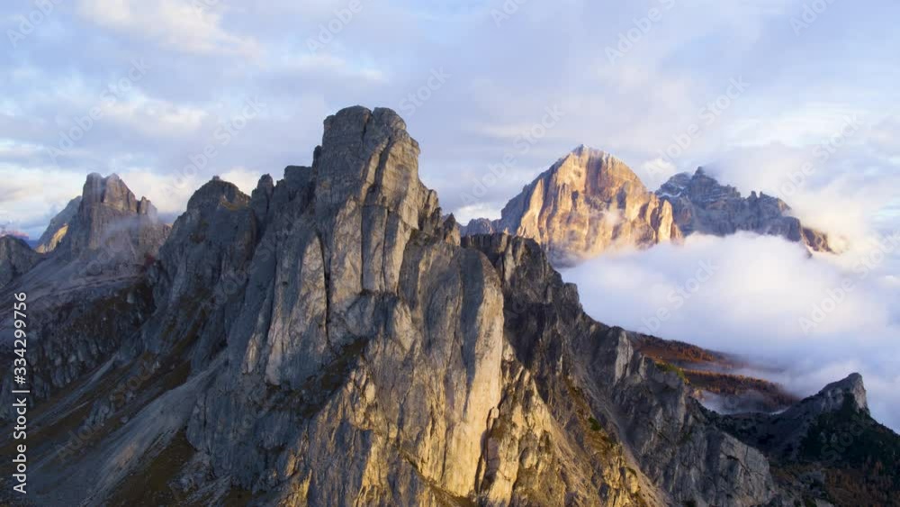 Aerial view of majestic dolomites mountains summit in the autumn sunset sun hidden behind the clouds. Golden hour. Aerial view of majestic dolomites mountains summit in the autumn sunset sun hidden behind the clouds. Golden hour.