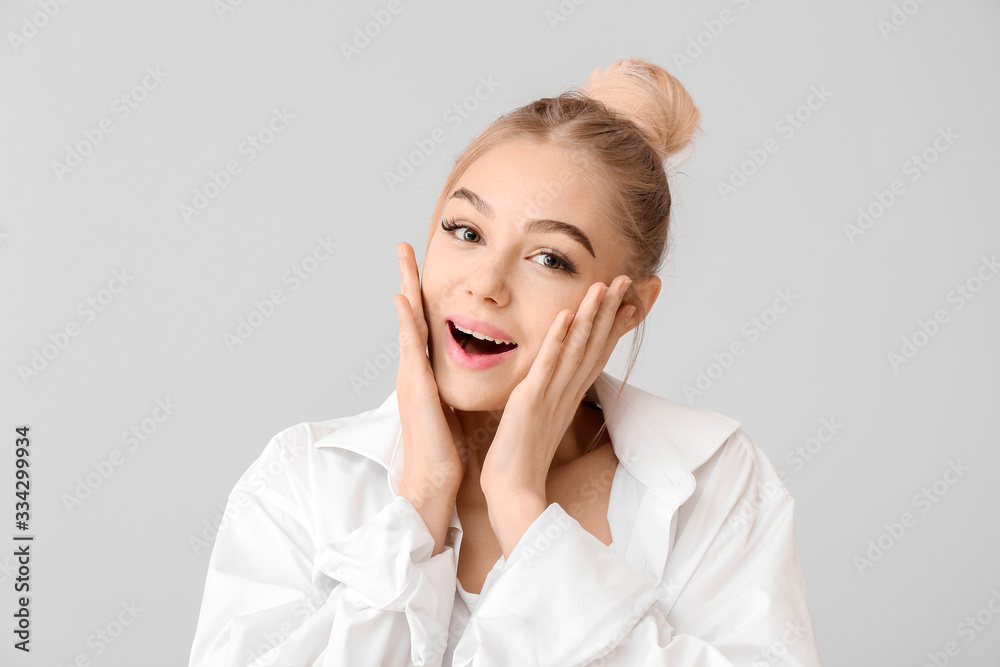 Surprised young woman on grey background Surprised young woman on grey background