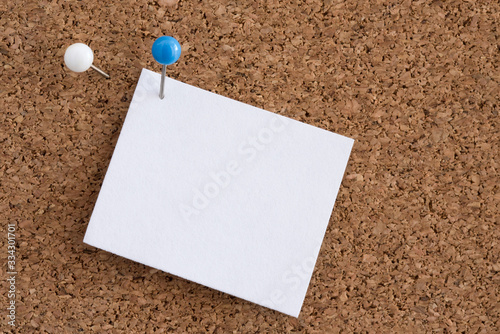 A Pin Holding Blank Paper to a Cork Board photo