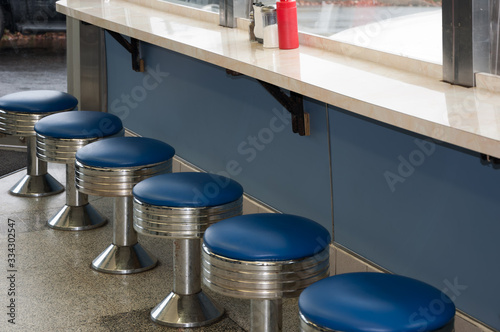 Retro 1950's blue diner stools in an old diner.