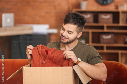 Young man unpacking box wit...