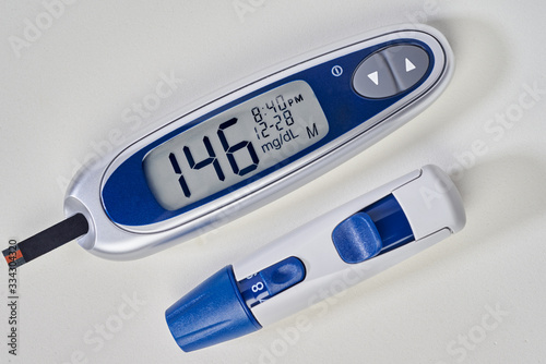 diabetes, glucometer with glucose measurement on screen and blood on test strip