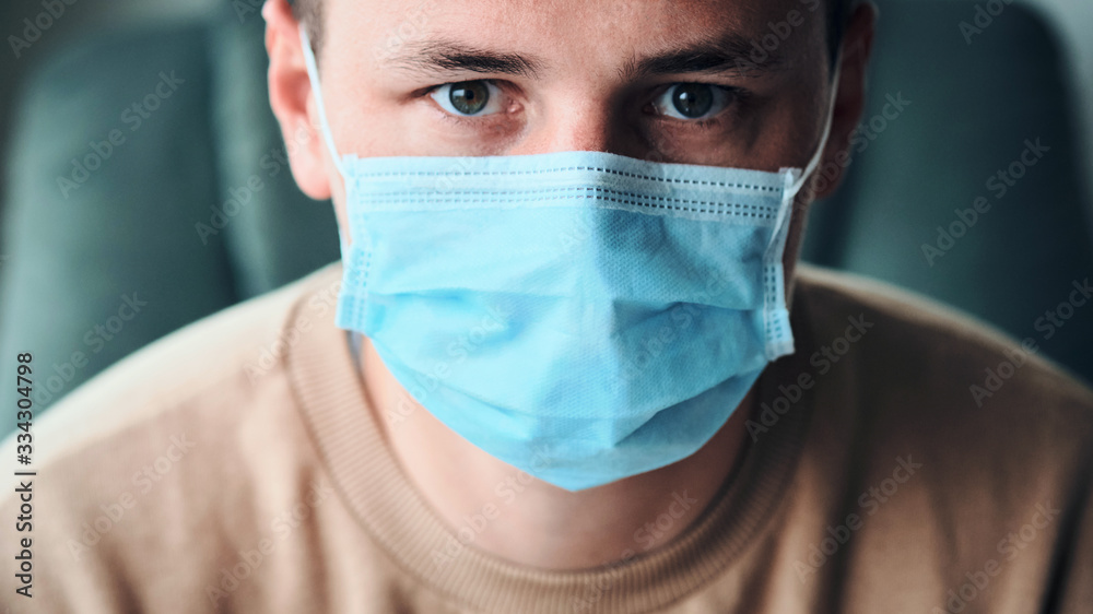 Close-up portrait of young man wearing medical mask and looking at the camera. Close-up portrait of young man wearing medical mask and looking at the camera.