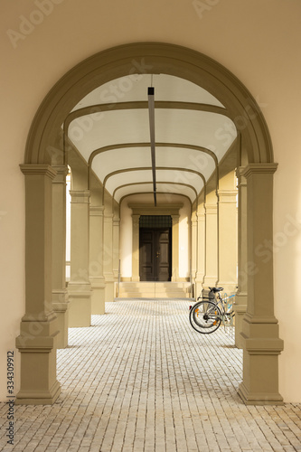 Beautiful walkway. Beige arch with bicycle on background photo